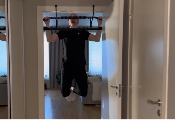Pullup i sammenleggbar pull-up bar montert på dør i hjemmet
