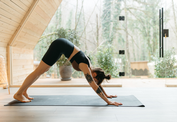 Tøying på yogamatte hjemme med natur i bakgrunn